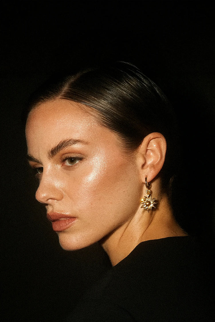 Close-up of a person wearing an earring with a dark background